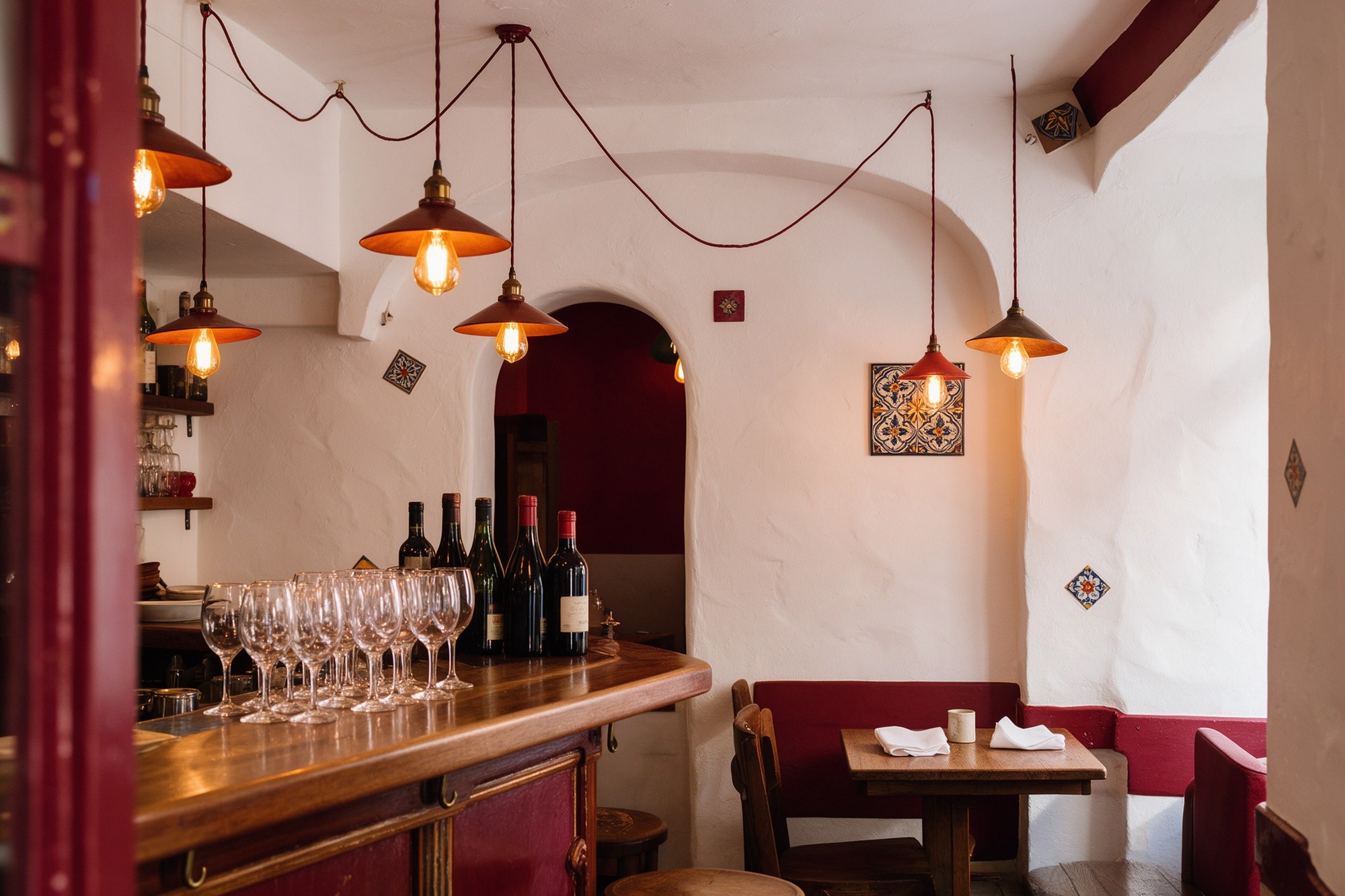 Interior de Taberna Lang con lámparas cálidas y barra de madera